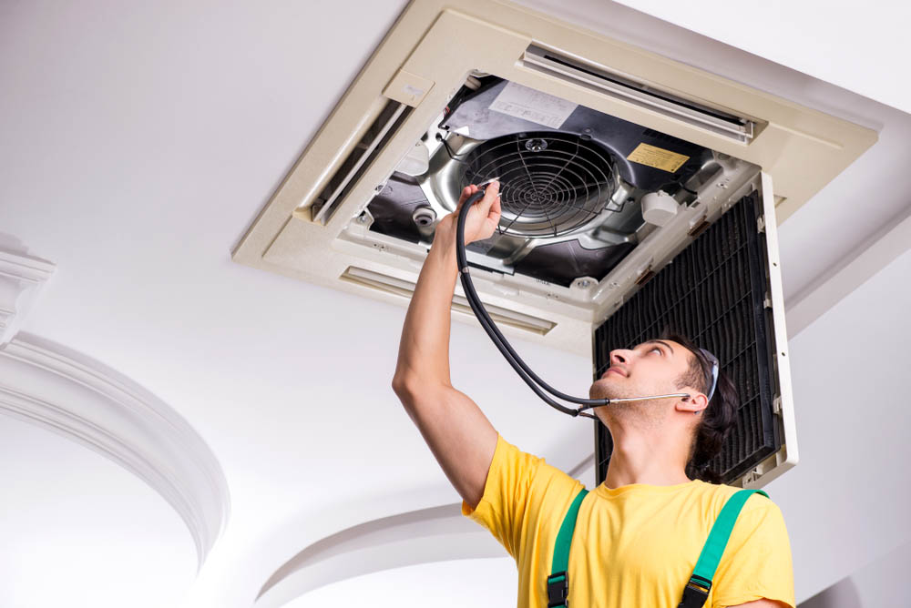 Person pressing ear (listening intently) against an HVAC unit Person pressing ear (listening intently) against an HVAC unit